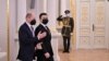 Esta fotografía tomada y publicada por el servicio de prensa presidencial de Ucrania muestra al presidente Volodymyr Zelensky dando la bienvenida al canciller alemán Olaf Scholz antes de su reunión en Kiev el 14 de febrero de 2022.