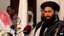 Muhammad Naeem, perwakilan dari Taliban, berbicara dengan media dalam pembukaan kantor mereka di Doha, Qatar (18/6). (AP/Osama Faisal)