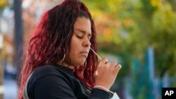 A resident uses a swab to take a coronavirus test at the Central Family Life Center, Nov. 10, 2020, in the Stapleton neighborhood of the Staten Island borough of New York. 