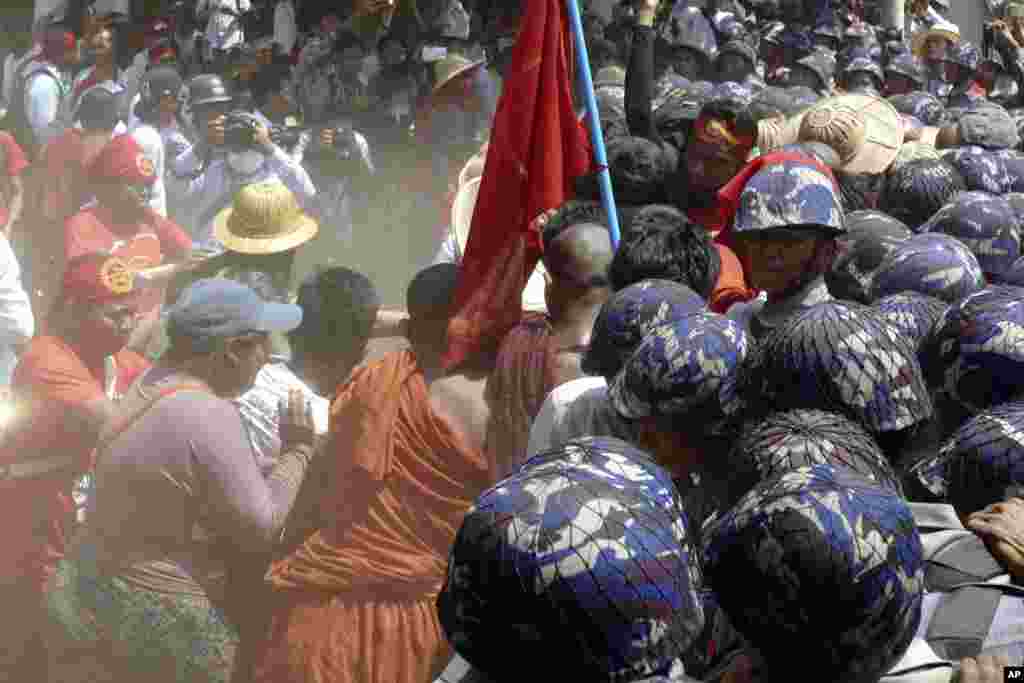 Para mahasiswa yang telah berdemonstrasi sejak 3 Maret mencoba mendorong blokade polisi di Letpadan, Myanmar (10/3). (AP/Khin Maung Win)