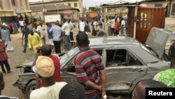 Mutane sun taru a inda aka samu fashewar Bom a Kano. Talata Yuli. 30, 2013.