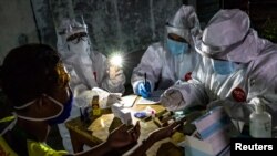 Petugas medis mengambil sampel rapid test dari pedagang di pasar tradisional untuk mencegah penyebaran virus Covid-19 di Semarang, Jawa Tengah, 22 Mei 2020. (Antara Foto/Aji Styawan/ via REUTERS)