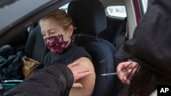 Una persona recibe una vacuna contra COVID-19 en un centro de vacunación directo al automóvil, el 2 de enero de 2022, en la Universidad St. Lawrence, de Kingston, Ontario.
