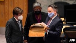 Permanent Representative of Ukraine to the United Nations Sergiy Kyslytsya, right, talks with U.S. Ambassador Linda Thomas-Greenfield, center, during an emergency meeting of the U.N. Security Council on the Ukraine crisis, in New York, Feb. 21, 2022.