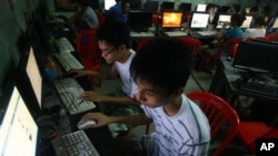 In this Sept. 27, 2012 photo, two Vietnamese students use Facebook at an Internet cafe near their dormitory while they could not log in Facebook from their mobile phones because of firewall in Hanoi, Vietnam. In Vietnam, new blogs, Facebook accounts and Twitter feeds are appearing everyday, attracting readers fed up with the state-controlled media and tales of corruption, police brutality and calls for freedom of expression.