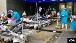 香港第5波新冠病毒疫情引致医疗系统超出负荷，明爱医院急症室外2月18日下午仍有大批等候入院的病人，被安排在户外的病床上 (美国之音/汤惠芸)