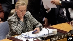 FILE - U.S. Secretary of State Hillary Rodham Clinton checks her mobile phone after her address to the Security Council at United Nations headquarters, March 12, 2012.