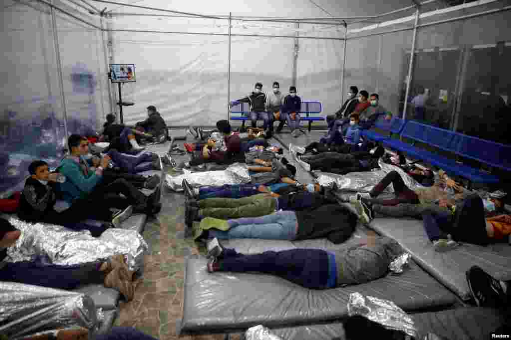 Los jóvenes migrantes descansan dentro de una cápsula en el centro de detención.
