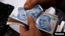 A money changer counts Turkish lira notes at a currency exchange office in Istanbul, Aug. 2, 2018. 