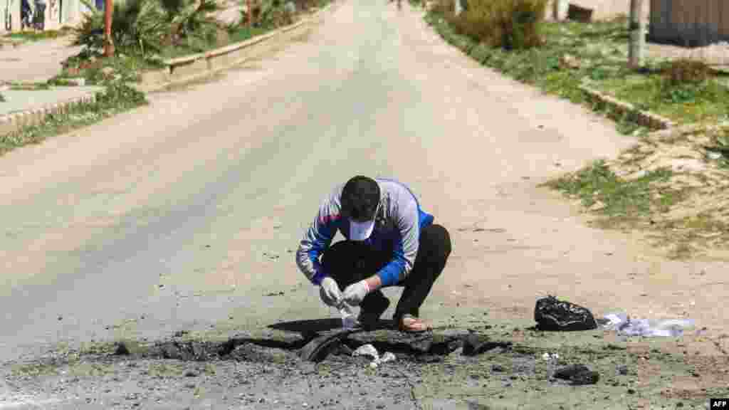 Un Syrien recueille des preuves sur le lieu de l'attaque chimique à Khan Sheikhun, le 5 avril 2017.