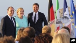 FILE - Italian Premier Matteo Renzi, right, French President Francois Hollande, left, and German Chancellor Angela Merkel stand on the deck of an Italian aircraft carrier off the coast of Italy, Aug. 22, 2016. The leaders of Italy, France and Germany are watching the U.S. election closely.
