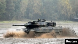 FILE - A Leopard 2 tank crosses a river during a German army, the Bundeswehr, training and information day in Munster, Germany, Oct. 9, 2015.