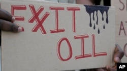 Una persona exhibe un cartel que demanda la salida de las empresas petroleras de la cumbre climática de la ONU COP28 en Dubái, el 4 de diciembre de 2023.