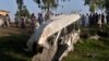 Penduduk setempat berkumpul di sekitar bus yang hancur akibat tabrakan dengan kereta api di Farooq Abad, distrik Sheikhupura, Pakistan, Jumat, 3 Juli 2020. 