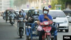 ពលរដ្ឋ​កម្ពុជា​​ពាក់ម៉ាស់​ ពេល​ធ្វើ​ដំណើរ​តាម​ដងផ្លូវ​ ខណៈ​កម្ពុជា​កំពុង​ប្រឈម​ការ​រាតត្បាត​នៃ​ជំងឺកូវីដ១៩​ នៅ​ភ្នំពេញ ថ្ងៃទី១០ ខែមីនា​ ឆ្នាំ២០២១។​ (ហ៊ាន​ សុជាតា/វីអូអេ)​