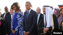 Presiden America Barack Obama dan ibu negara Michelle Obama disambut raja baru Saudi, Salman bin Abdul-Aziz Al Saud (kanan) setibanya di bandara Internasional King Khalid di Riyadh, Arab Saudi (27/1).