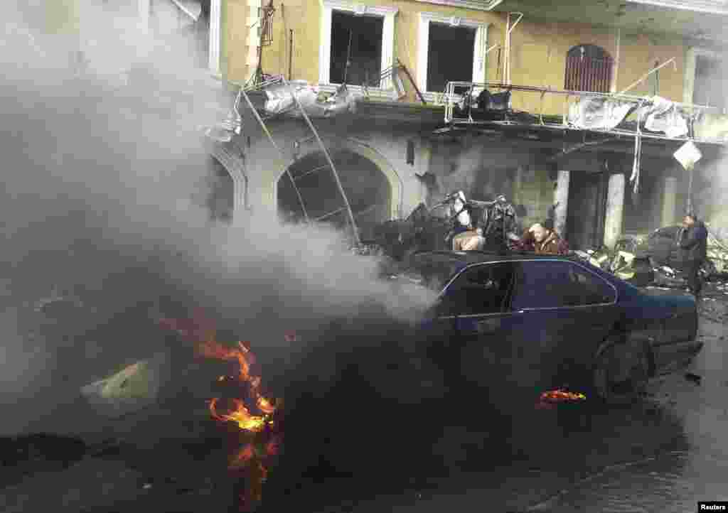 A man reacts near a burning car at the site of an explosion in the Shi'ite town of Hermel, Jan. 16, 2014.