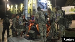 敘利亞反抗軍在奪取北部最大城市阿勒頗後11月30日在市內一個廣場取暖。