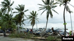La gente mira los escombros y los barcos apilados después de que el huracán Julia pasa por la isla de San Andrés, Colombia, 9 de octubre de 2022.