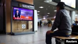 13일 한국 서울 시내 철도역 이용객이 북한 미사일 발사 TV 뉴스를 시청하고 있다.