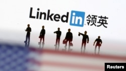Pequeñas figuras de juguete se pueden observar entre la bandera de EE. UU. y el logotipo de LinkedIn en esta imagen de ilustración, el 30 de agosto de 2018. 