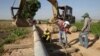 FILE PHOTO - Cambodian workers prepare an electricity pole for placing at Samroang Tiev village at the outskirt of Phnom Penh, Cambodia, Thursday, Dec. 7, 2017. (AP Photo/Heng Sinith)