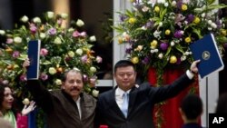 En esta fotografía de archivo del 14 de junio de 2013, el presidente Daniel Ortega, izquierda, y el empresario chino Wang Jing sostienen un acuerdo de concesión para la construcción de un canal multimillonario en la Casa de los Pueblos en Managua. AP