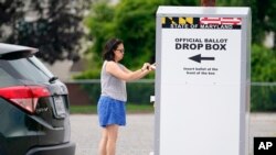 ARCHIVO - Una mujer inserta una boleta en un buzón de votación durante las elecciones primarias de Maryland, el martes 19 de julio de 2022, en Baltimore. 