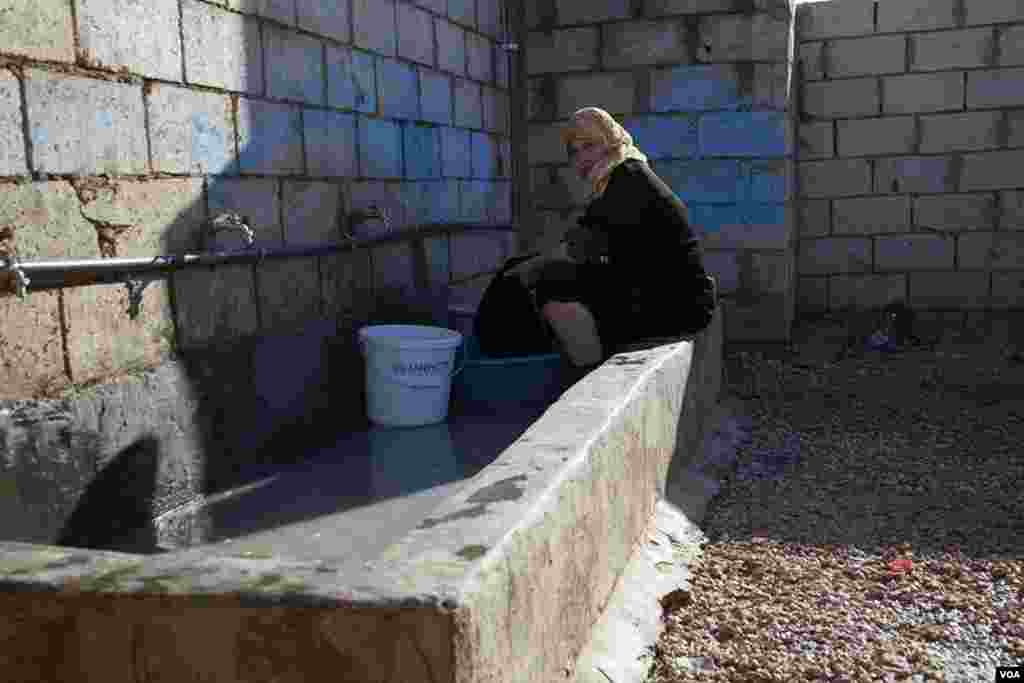 A woman washes clothes in the Za'tari refugee camp. (Y. Weeks/VOA)