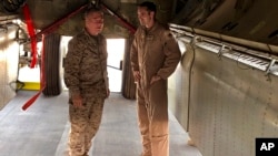 El general de Infantería de Marina Frank McKenzie, jefe del Comando Central de Estados Unidos, conversa con un oficial de la Fuerza Aérea debajo de un bombardero B-52 el viernes 7 de junio de 2019, en la base aérea de al-Udeid, en Qatar.