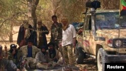 Des combattants séparatistes touaregs du groupe rebelle MNLA se reposent sous l'ombre d'un arbre dans le désert près de Tabankort, Mali, le 13 février 2015. 