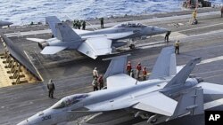 Okinavadagi AQShning FA-18 qiruvchi samalyotlari uchishga hozirlanmoqda.
