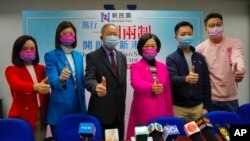 Members of New People's Party, from left, Judy Chan, Eunice Yung, Lai Tung-kwok, Regina Ip, Dominic Lee and Marcus Liu pose for a photograph after winning the legislative election in Hong Kong, Dec. 20, 2021. (AP Photo/Kin Cheung)