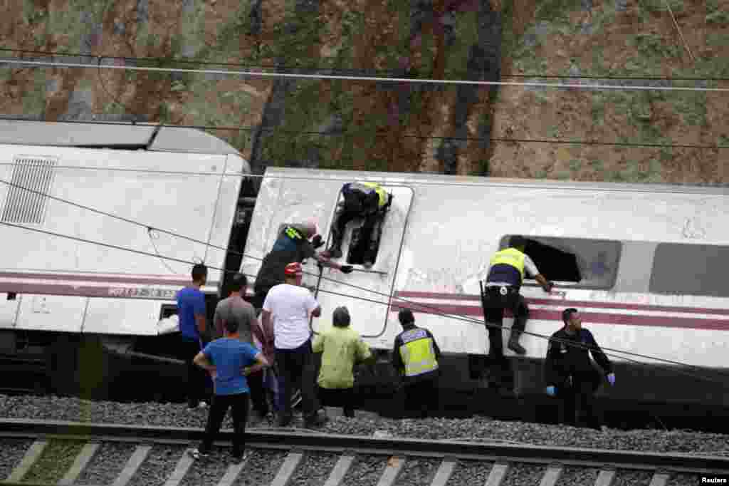 Rescue workers pull victims from a train crash near Santiago de Compostela, northwestern Spain, July 24, 2013. 