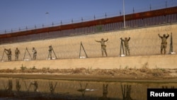 Miembros de la Guardia Nacional de Texas colocan alambrada a orillas del río Bravo, en la frontera de Estados Unidos con México, con el propósito de reforzar la seguridad y desalentar el cruce de migrantes; visto desde Ciudad Juárez, México, el 22 de agosto de 2023.