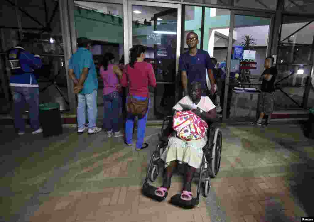 Patients wait outside a clinic that was evacuated after tremors were felt resulting from an earthquake in Cali, Colombia, April 16, 2016.
