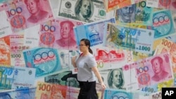 2019年8月6日香港中环一家货币兑换店前走过的行人