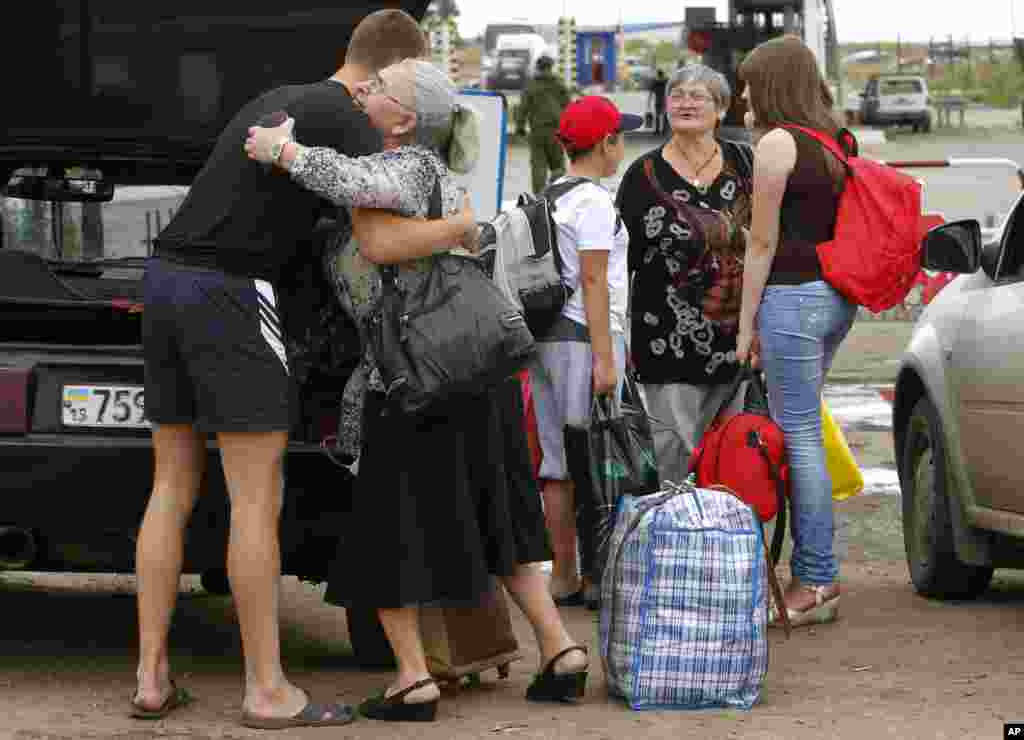 A man says goodbye to his relatives as they prepare to cross the border into Russia at the checkpoint in Izvaryne, Luhansk region, eastern Ukraine, June 26, 2014.