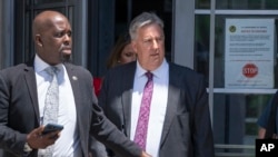 El abogado del expresidente Donald Trump, James Trusty (derecha), sale del edificio del Departamento de Justicia, el lunes 5 de junio de 2023, en Washington. (AP Foto/Jacquelyn Martin)
