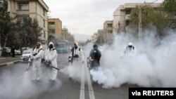 Members of firefighters wear protective face masks, amid fear of coronavirus disease (COVID-19), as they disinfect the streets, ahead of the Iranian New Year Nowruz, March 20, in Tehran, Iran March 18, 2020. Picture taken March 18, 2020. WANA (West…