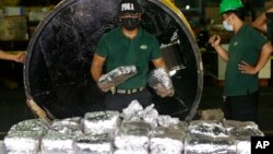 Anggota Lembaga Anti Narkotika Filipina (PDEA) mengumpulkan kantong-kantong berisi Methamphetamine Hydrochloride alias sabu-sabu yang disembunyikan dalam sebuah tabung baja. Manila, Filipina, 7 Agustus 2018 (foto: AP Photo/Aaron Favila)