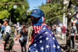 FILE PHOTO: A man dressed in an American flag joins protesters in Portland, Oregon, Aug. 31, 2020.