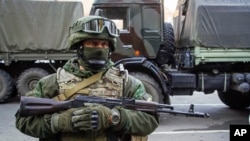 FILE - A Russia-backed rebel stands guard during preparation for an exchange of prisoners in Donetsk, eastern Ukraine, Oct. 29, 2015. The Ukrainian military said five of its soldiers have been killed in 24 hours ending Nov. 14, 2015. 