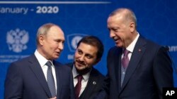 Turkey's President Recep Tayyip Erdogan, right and Russia's President Vladimir Putin, left, talk after they symbolically open a valve during a ceremony in Istanbul for the inauguration of the TurkStream pipeline, Jan. 8, 2020.