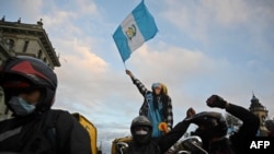 Mensajeros de entrega de alimentos participan en una protesta para exigir la renuncia del presidente guatemalteco Alejandro Giammattei, en Ciudad de Guatemala, el 22 de noviembre de 2020.