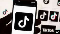 The TikTok logo is seen on a cellphone on Oct. 14, 2022, in Boston. A U.S. Commerce Department official describes TikTok as a threat.