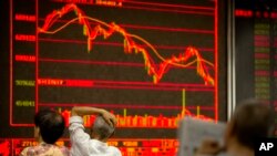 Chinese investors monitor stock prices at a brokerage house in Beijing, July 6, 2018.