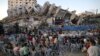 Musisi Palestina tampil di antara reruntuhan Menara Hanadi selama acara yang diselenggarakan oleh Komite Pemuda dan Kebudayaan Palestina di Kota Gaza, Rabu 2 Juni 2021 (Foto: AFP). 