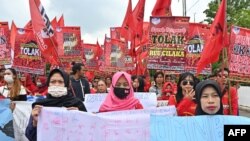 Para pekerja berpawai menuju gedung DPR/MPR untuk memprotes rancangan undang-undang omnibus penciptaan lapangan kerja, di Jakarta, 13 Januari 2020. (Foto: AFP)