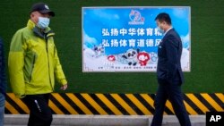 2021年12月8日，行人在北京走过一张宣传2022年冬季奥运会的海报。（美联社照片）